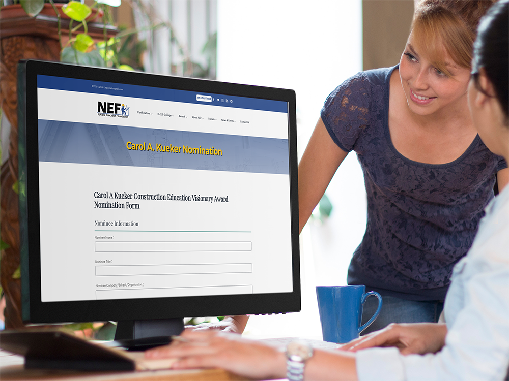 Two women at a computer that has the website nomination form for the Carol A. Kueker Award pulled up on screen.